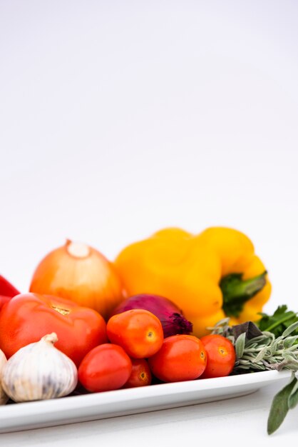 Close-up of healthy fresh organic vegetables in tray over white background