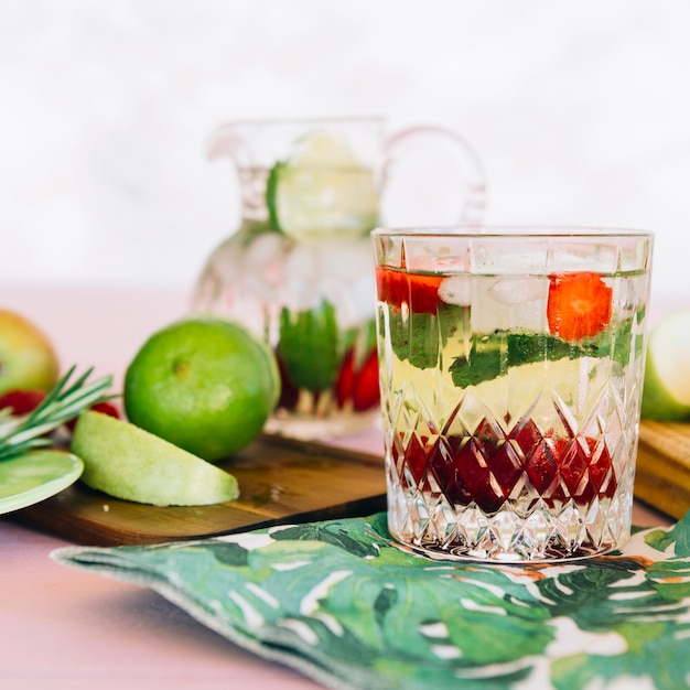 Close-up of healthy juice with ingredients near fruits on chopping board