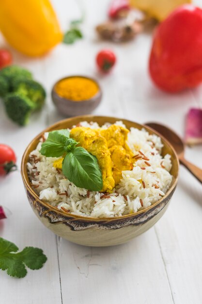 Close-up of healthy rice; basil leaves and chicken in bowl