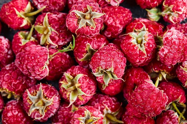 Close up heap of fresh raspberries on dark background. 