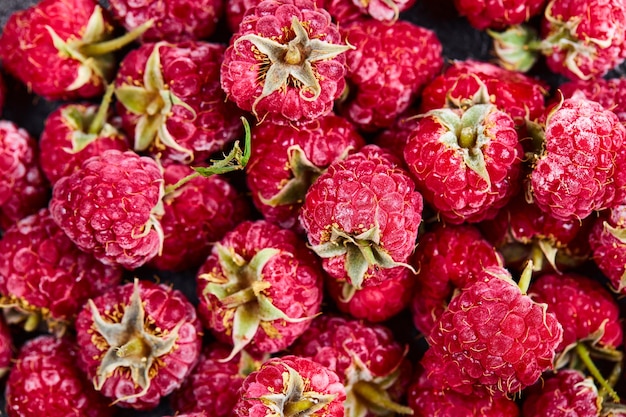 Close up heap of fresh raspberries on dark background. 