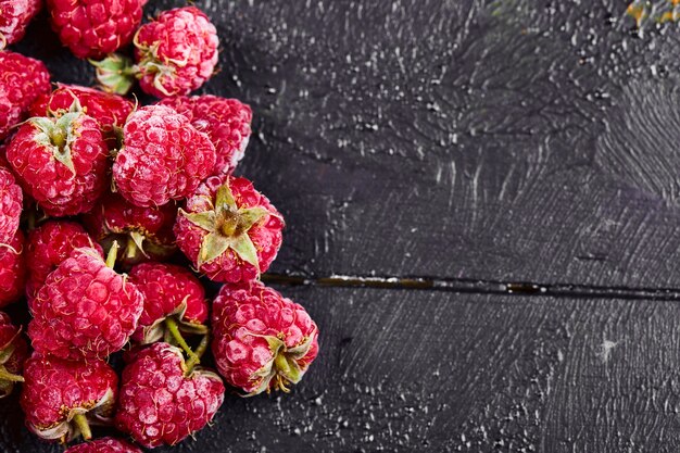 Close up heap of fresh raspberries on dark background. 