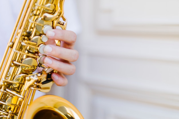 Free photo close up held saxophone with blurred background