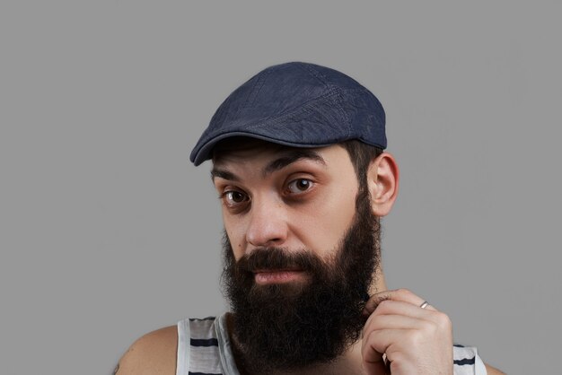 Close up high detailed portrait of caucasian bearded man isolated on grey background and look to the camera.