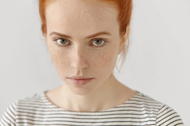 Foto gratuita ritratto altamente dettagliato del primo piano del modello femminile della giovane rossa stupefacente con gli occhi verdi