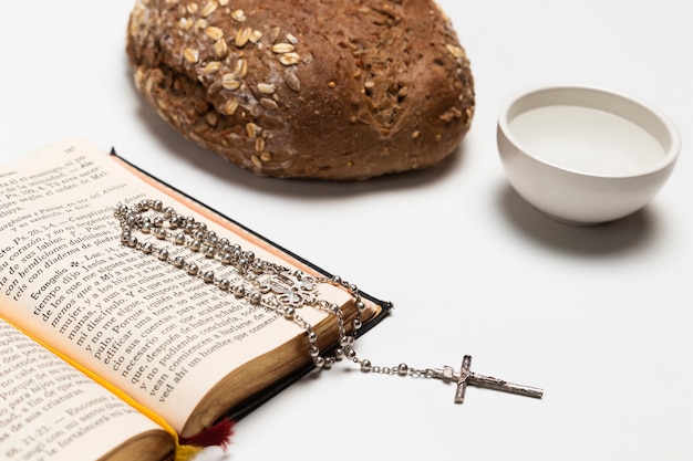 Free photo close-up holy book with bread and water