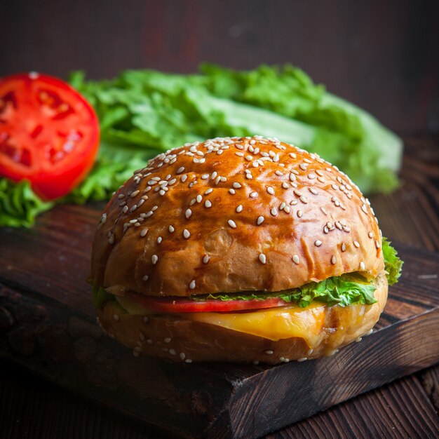 Close-up homemade burger on wooden cutting board with cheese