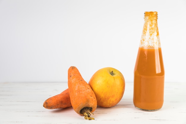 Foto gratuita chiuda sul frullato casalingo della carota sulla tavola