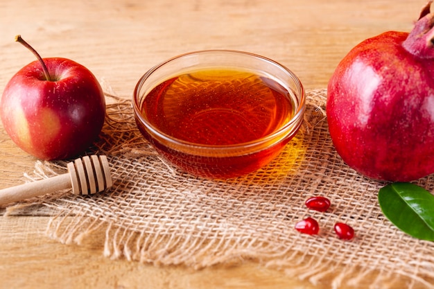 Close up honey bowl with dipper and fruits