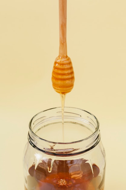 Free photo close-up honey pouring into jar