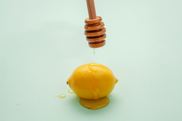 Close-up honey pouring on a lemon