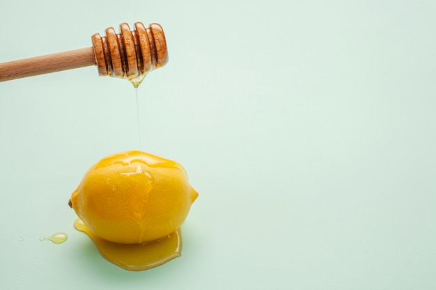 Close-up honey pouring on a lemon