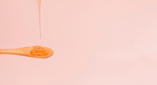 Close-up honey pouring on a spoon