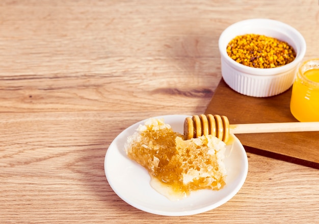 Close-up of honeycomb and bee pollen on wooden desk