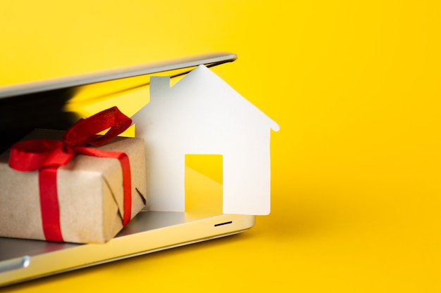 Close-up house figure with present and laptop