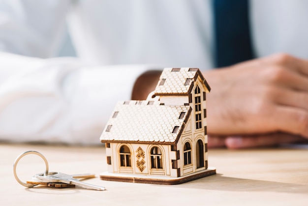 Close-up house and keys near real estate agent