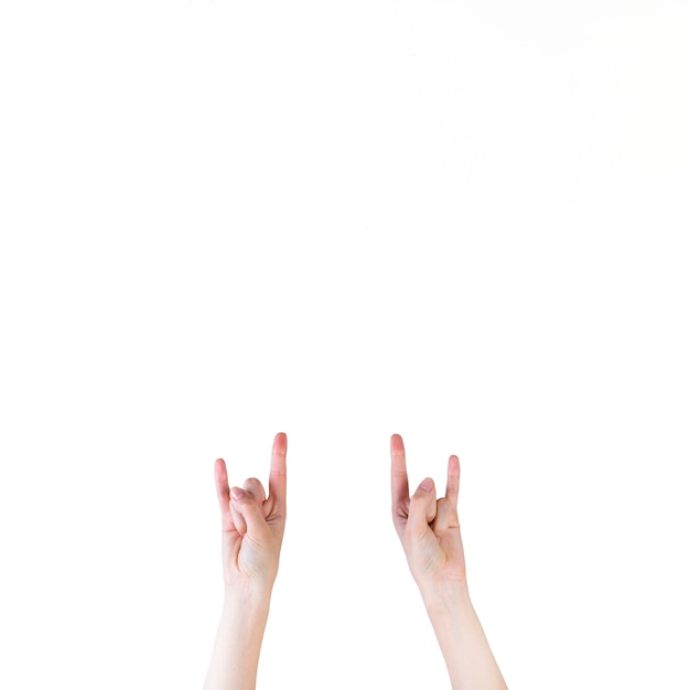 Close-up of a human hand making rock sign on white background