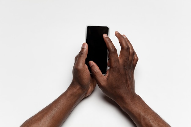 Primo piano della mano umana che utilizza smartphone con schermo nero vuoto, concetto educativo e aziendale
