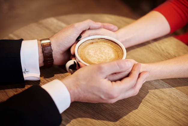 Close up of human hands holding cup of coffee