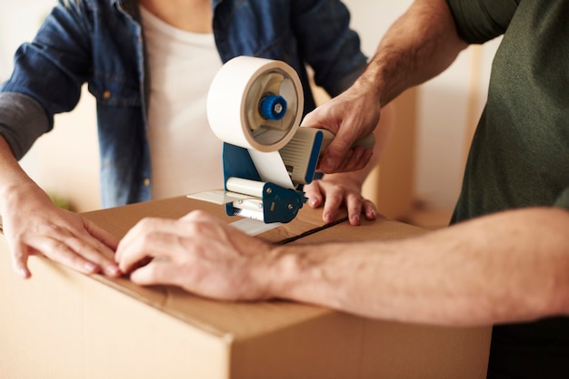 Close up of human hands sticking cartons