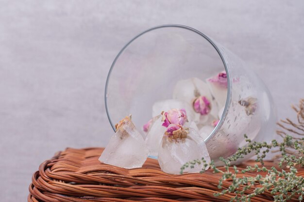 Close up iced flowers in glass on basket.