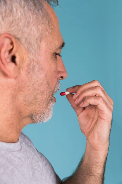 Close-up of a ill man taking capsule