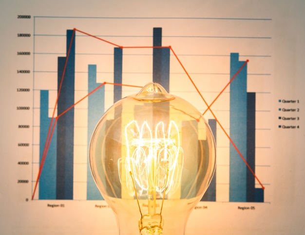 Free photo close-up of illuminated light bulb with chart background