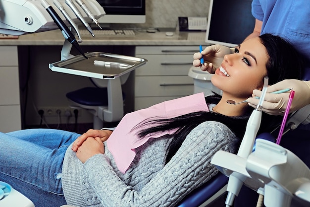 Immagine ravvicinata di un dentista che esamina i denti della femmina in odontoiatria.