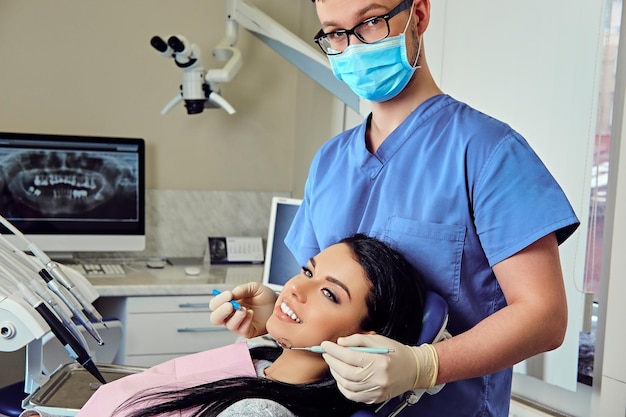 歯科で女性の歯を調べている歯科医のクローズアップ画像。