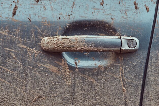 田舎を旅した後の汚れた車のクローズアップ画像。ドアハンドル。