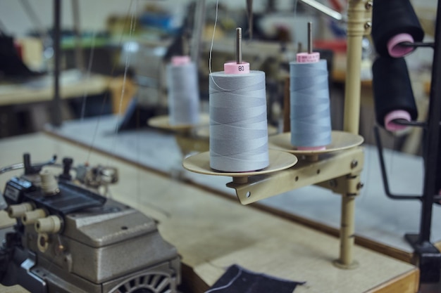 Крупный план множества катушек с нитками в швейной мастерской.