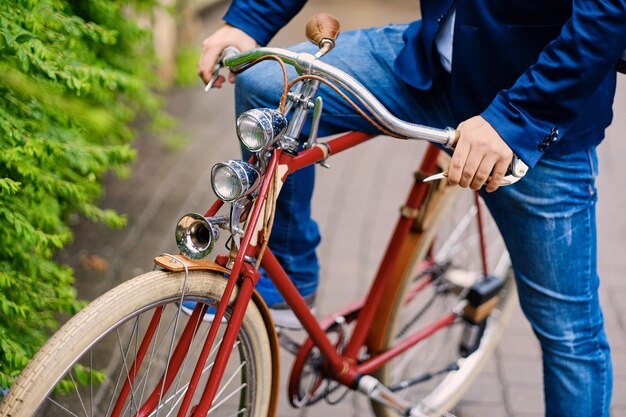 レトロな自転車に乗っている男の画像をクローズアップ。