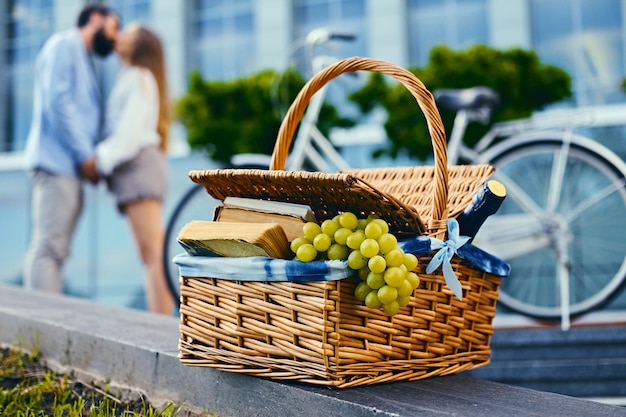 Close up image of picnic basket full of fruits, bread and wine.