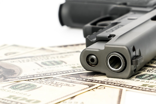 Close up image of pistol and dollar .