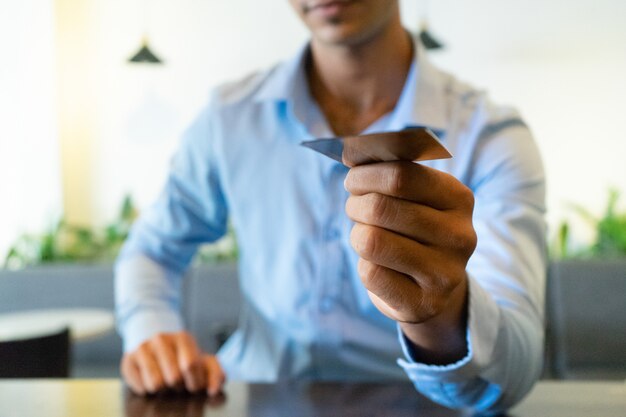 Close-up of Indian businessman hand giving business card.