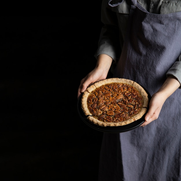 Close-up individual holding homemade pecan pie