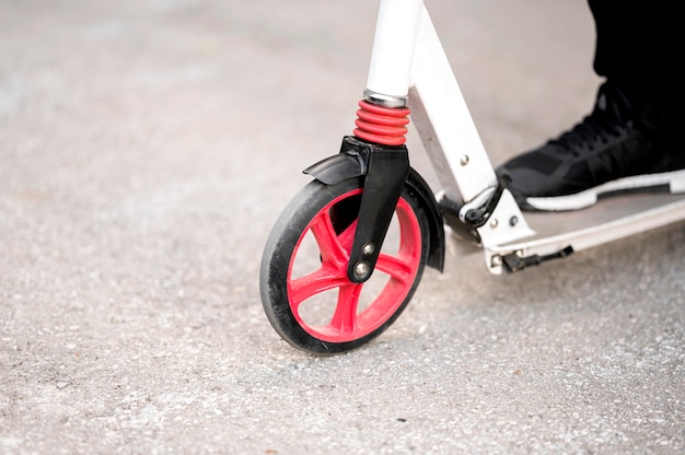 Close-up individual riding scooter