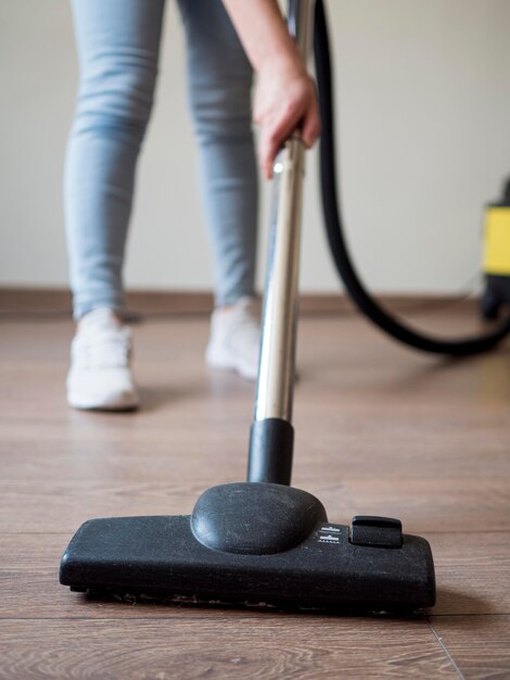 Close-up individual using vacuum cleaner