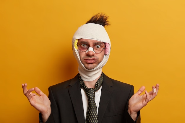 Free photo close up on injured man with dark bruise under eyes and brain concussion, wears bandage