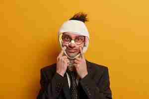 Free photo close up on injured man with dark bruise under eyes and brain concussion, wears bandage