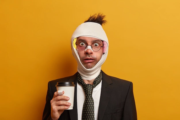 Close up on injured man with dark bruise under eyes and brain concussion, wears bandage