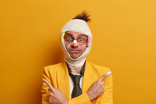 Close up on injured man with dark bruise under eyes and brain concussion, wears bandage