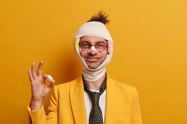 Close up on injured man with dark bruise under eyes and brain concussion, wears bandage