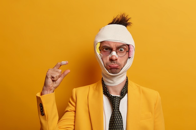 Free photo close up on injured man with dark bruise under eyes and brain concussion, wears bandage