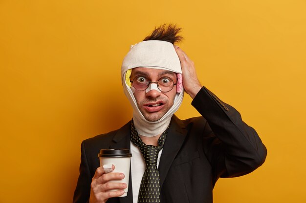 Close up on injured man with dark bruise under eyes and brain concussion, wears bandage