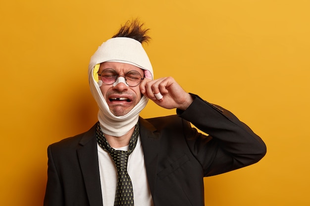 Free photo close up on injured man with dark bruise under eyes and brain concussion, wears bandage