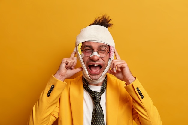 Free photo close up on injured man with dark bruise under eyes and brain concussion, wears bandage