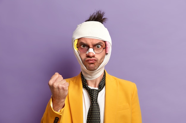 Free photo close up on injured man with dark bruise under eyes and brain concussion, wears bandage