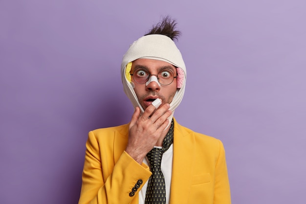 Free photo close up on injured man with dark bruise under eyes and brain concussion, wears bandage