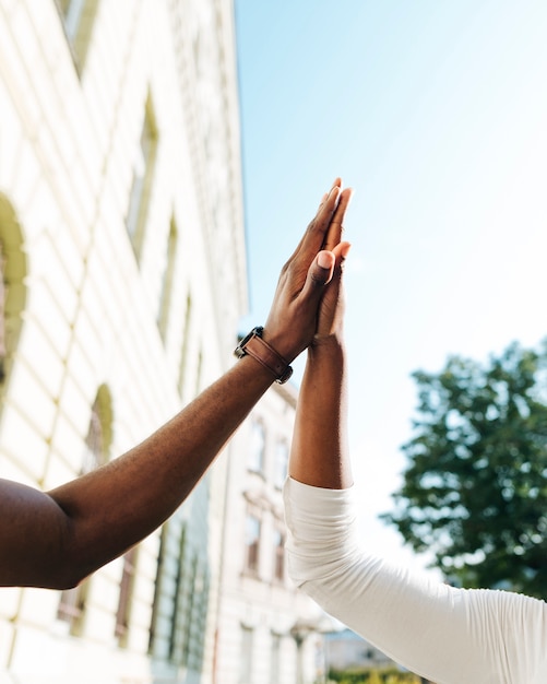 Close-up intercultural high five in air